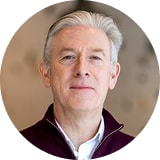 Close-up portrait of a middle-aged man with gray hair in a circular frame
